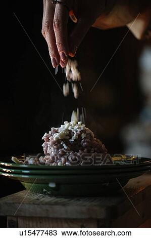 Young woman adding garnish to bowl of risotto, close up of hand View Large Photo Image Stock Image - Young woman adding garnish to bowl of risotto, close up of hand. Fotosearch
