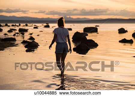 Young woman ankle deep in water at sunset, Quadra Island, Campbell River, Canada View Large Photo Image Stock Photography - Young woman ankle deep in water at sunset, Quadra Island, Campbell River, Canada. Fotosearch