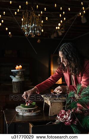 Young woman at rustic table garnishing food View Large Photo Image Stock Photo - Young woman at rustic table garnishing food. Fotosearch