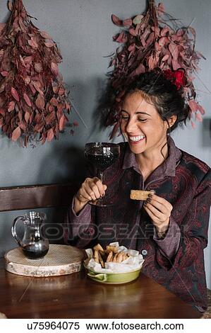 Young woman at rustic table holding glass of red wine View Large Photo Image Stock Photography - Young woman at rustic table holding glass of red wine. Fotosearch