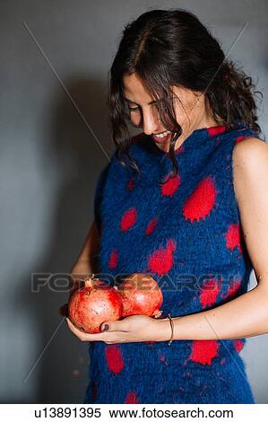 Young woman in red patterned dress holding pomegranates View Large Photo Image Stock Photography - Young woman in red patterned dress holding pomegranates. Fotosearch