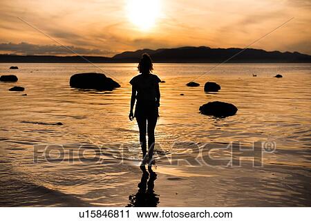 Young woman looking out at sunset, silhouetted rear view, Quadra Island, Campbell River, Canada View Large Photo Image Stock Image - Young woman looking out at sunset, silhouetted rear view, Quadra Island, Campbell River, Canada. Fotosearch