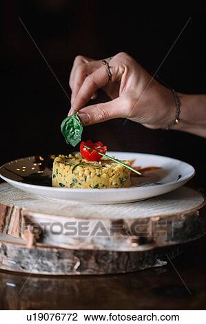 Young woman putting basil garnish on food, close up of hand View Large Photo Image Stock Image - Young woman putting basil garnish on food, close up of hand. Fotosearch