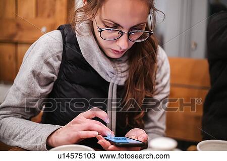 Young woman using smartphone in cafe View Large Photo Image Stock Image - Young woman using smartphone in cafe. Fotosearch