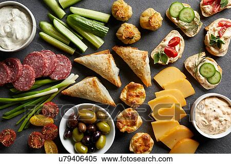 Stock Photography - Appetiser snack spread with open sandwiches, olives and cheese, overhead view. Fotosearch