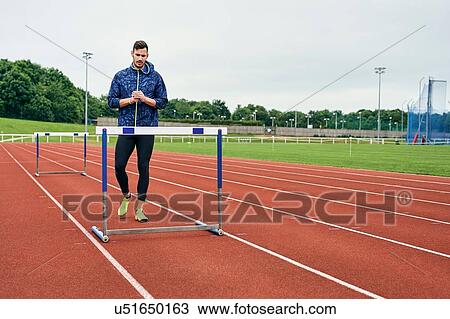 Athlete walking beside hurdle on running track View Large Photo Image Stock Image - Athlete walking beside hurdle on running track. Fotosearch