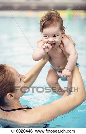 Stock Photograph - Baby with mother in swimming pool. Fotosearch