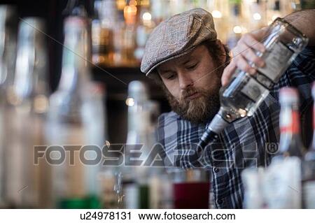 Barman pouring spirit bottle in traditional Irish public house View Large Photo Image Stock Image - Barman pouring spirit bottle in traditional Irish public house. Fotosearch