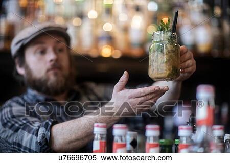 Barman serving jar glass cocktail in traditional Irish public house View Large Photo Image Stock Photography - Barman serving jar glass cocktail in traditional Irish public house. Fotosearch