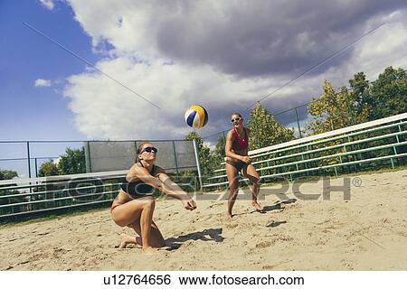 Stock Photograph - Beach volleyball duel on the net. Fotosearch