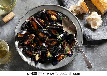 Bowl of garlic mussels with glass of white wine, overhead view View Large Photo Image Picture - Bowl of garlic mussels with glass of white wine, overhead view. Fotosearch