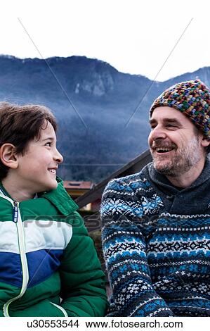Picture - Boy and father looking at each other on lakeside pier, Lake Como, Onno, Lombardy, Italy. Fotosearch
