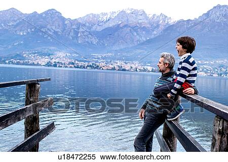Boy and father looking out from lakeside pier, Lake Como, Onno, Lombardy, Italy View Large Photo Image Stock Photography - Boy and father looking out from lakeside pier, Lake Como, Onno, Lombardy, Italy. Fotosearch