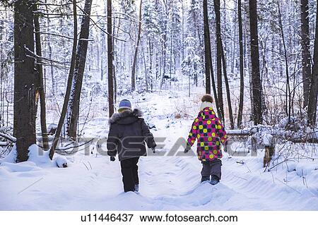 Boy and girl walking in snow covered forest, rear view View Large Photo Image Stock Photo - Boy and girl walking in snow covered forest, rear view. Fotosearch