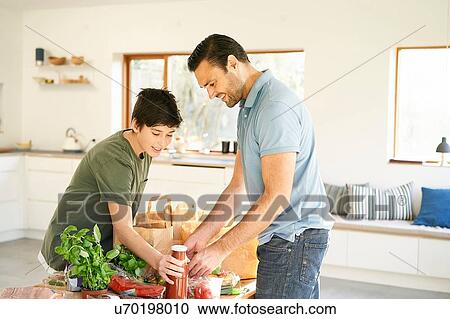 Boy and his father at kitchen counter unpacking groceries View Large Photo Image Stock Image - Boy and his father at kitchen counter unpacking groceries. Fotosearch