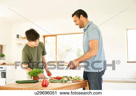 Boy and his father preparing food at kitchen counter View Large Photo Image Stock Image - Boy and his father preparing food at kitchen counter. Fotosearch