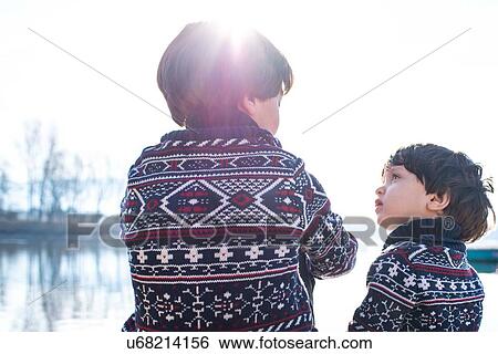 Boy and toddler brother in matching sweaters talking on lakeside, Lake Como, Lecco, Lombardy, Italy View Large Photo Image Stock Photograph - Boy and toddler brother in matching sweaters talking on lakeside, Lake Como, Lecco, Lombardy, Italy. Fotosearch