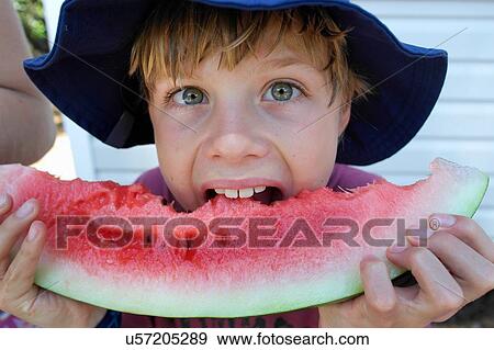 Stock Photo - Boy biting into watermelon. Fotosearch