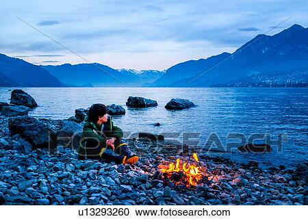 Boy by campfire at dusk, Onno, Lombardy, Italy View Large Photo Image Stock Image - Boy by campfire at dusk, Onno, Lombardy, Italy. Fotosearch