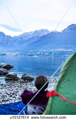Boy looking out over lake from tent, rear view, Lake Como, Onno, Lombardy, Italy View Large Photo Image Picture - Boy looking out over lake from tent, rear view, Lake Como, Onno, Lombardy, Italy. Fotosearch