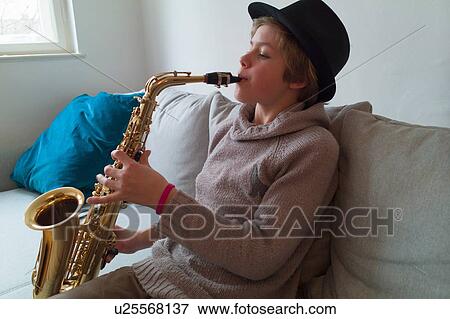Boy practising saxophone on sofa View Large Photo Image Stock Photo - Boy practising saxophone on sofa. Fotosearch