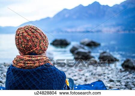 Boy sitting on blanket on lakeside, rear view, Lake Como, Onno, Lombardy, Italy View Large Photo Image Picture - Boy sitting on blanket on lakeside, rear view, Lake Como, Onno, Lombardy, Italy. Fotosearch