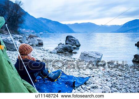 Boy sitting outside tent on lakeside, Lake Como, Onno, Lombardy, Italy View Large Photo Image Picture - Boy sitting outside tent on lakeside, Lake Como, Onno, Lombardy, Italy. Fotosearch