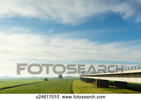 Stock Image - Bridge crossing floodland and river Waal (dutch part of the Rhine) in autumn, Netherlands. Fotosearch