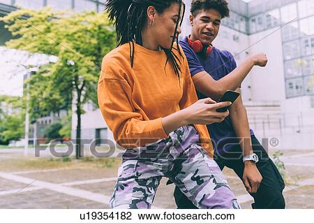 Brother and sister dancing to footage on mobile, Milan, Italy View Large Photo Image Stock Image - Brother and sister dancing to footage on mobile, Milan, Italy. Fotosearch