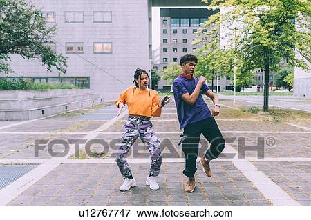 Brother and sister dancing to footage on mobile, Milan, Italy View Large Photo Image Stock Photo - Brother and sister dancing to footage on mobile, Milan, Italy. Fotosearch