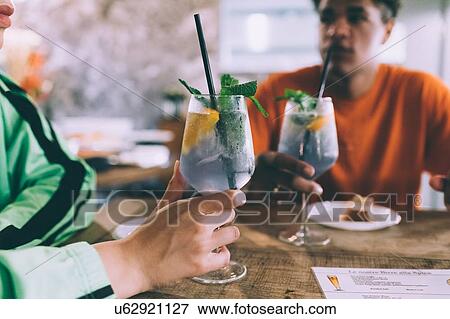 Stock Photo - Brother and sister having drinks in bar. Fotosearch