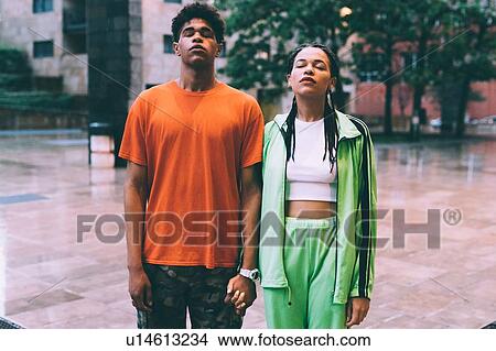 Picture - Brother and sister side by side with eyes closed, Milan, Italy. Fotosearch