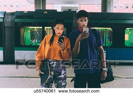 Brother and sister texting at tram stop, Milan, Italy View Large Photo Image Stock Image - Brother and sister texting at tram stop, Milan, Italy. Fotosearch