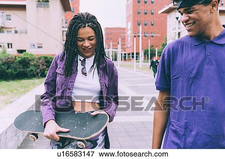 Stock Photo - Brother and sister walking and talking, Milan, Italy. Fotosearch