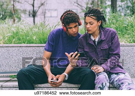 Brother and sister watching footage on mobile phone together, Milan, Italy View Large Photo Image Stock Image - Brother and sister watching footage on mobile phone together, Milan, Italy. Fotosearch