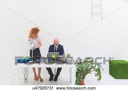 Businessman and woman having discussion in office View Large Photo Image Stock Image - Businessman and woman having discussion in office. Fotosearch