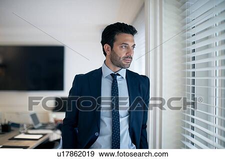 Businessman deep in thoughts beside window View Large Photo Image Stock Photo - Businessman deep in thoughts beside window. Fotosearch
