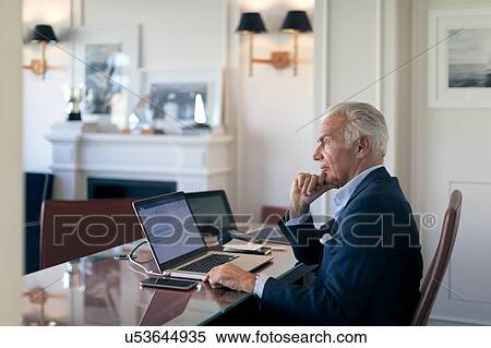 Stock Photography - Businessman deep in thoughts in office. Fotosearch