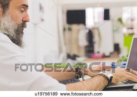 Businessman typing on laptop at office desk, cropped View Large Photo Image Stock Photo - Businessman typing on laptop at office desk, cropped. Fotosearch