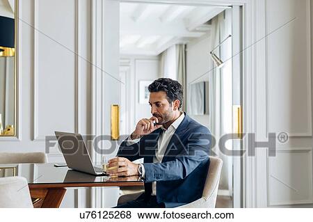 Businessman using laptop in suite View Large Photo Image Stock Photo - Businessman using laptop in suite. Fotosearch