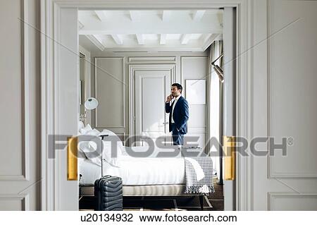 Businessman using smartphone in suite View Large Photo Image Stock Image - Businessman using smartphone in suite. Fotosearch