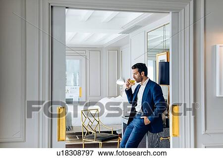 Businessman with iced drink, deep in thoughts in suite View Large Photo Image Stock Photo - Businessman with iced drink, deep in thoughts in suite. Fotosearch