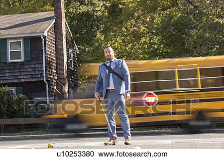 Stock Image - Businessman with visual impairment outside with his cane. Fotosearch