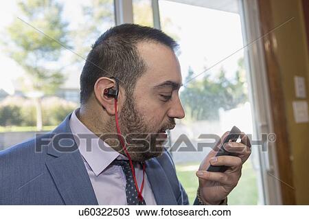 Stock Image - Businessman with visual impairment using phone. Fotosearch