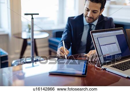 Businessman writing on digital tablet in office View Large Photo Image Stock Photograph - Businessman writing on digital tablet in office. Fotosearch