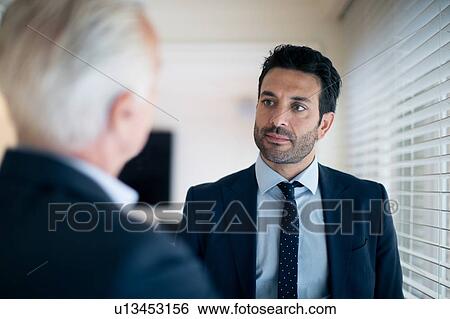 Stock Photograph - Businessmen talking in office. Fotosearch