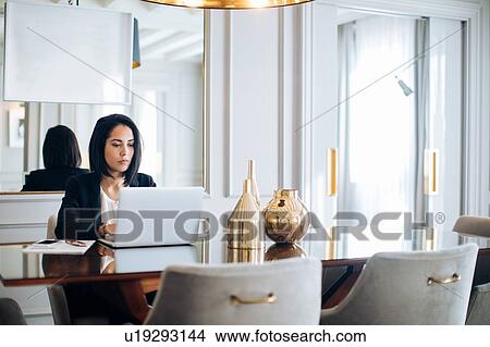 Businesswoman using laptop in suite View Large Photo Image Picture - Businesswoman using laptop in suite. Fotosearch