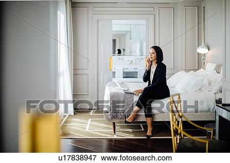 Businesswoman using smartphone and laptop in suite View Large Photo Image Stock Photo - Businesswoman using smartphone and laptop in suite. Fotosearch