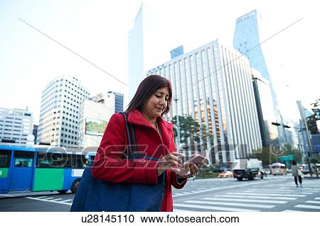 Businesswoman using smartphone in city, Seoul, South Korea View Large Photo Image Stock Image - Businesswoman using smartphone in city, Seoul, South Korea. Fotosearch
