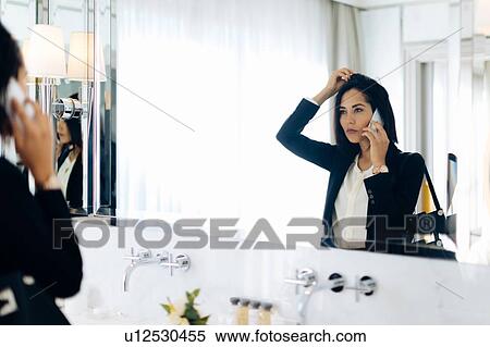 Businesswoman using smartphone in bathroom of suite View Large Photo Image Stock Photography - Businesswoman using smartphone in bathroom of suite. Fotosearch